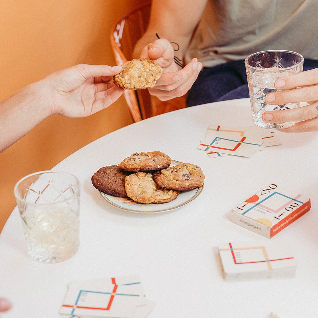 A plate of Gluten-Free Cookies on a table with friends playing games